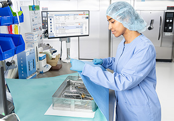Staff wrapping a surgical instrument basket