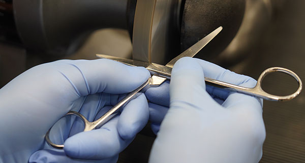 Technician sharpening a surgical instrument