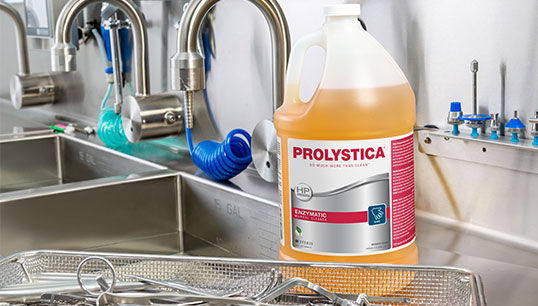 Sterile processing worker conducting manual cleaning at the sink with Prolystica products