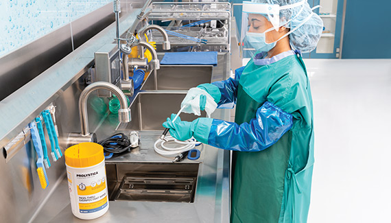 Sterile processing technician using PROLYSTICA™ Pass-Thru Disinfectant Wipes