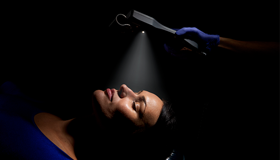 Patient laying down with remote flashlight shining on patient face