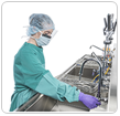 Technician Washing Surgical Instruments at Decontamination Sink